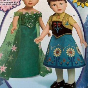 Peut inclure: Deux poup&eacute;es portant des costumes du film "Frozen Fever". L'une porte une robe verte avec des fleurs roses et une cape transparente. L'autre porte une jupe bleue avec des d&eacute;tails de fleurs jaunes et un gilet jaune. Le texte "Simplicity 1088" est visible.