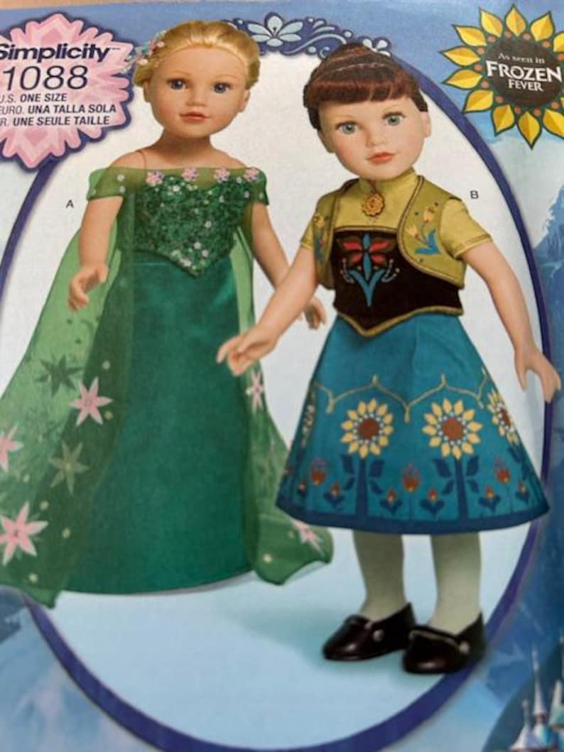Peut inclure: Deux poup&eacute;es portant des costumes du film "Frozen Fever". L'une porte une robe verte avec des fleurs roses et une cape transparente. L'autre porte une jupe bleue avec des d&eacute;tails de fleurs jaunes et un gilet jaune. Le texte "Simplicity 1088" est visible.