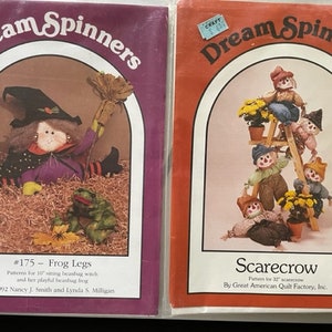May include: Two sewing patterns for beanbag dolls. The first pattern is for a witch with frog legs and the second pattern is for a scarecrow. The patterns are from Dream Spinners and are titled "#175 - Frog Legs" and "Scarecrow".