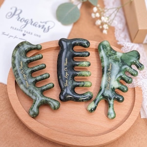 May include: Three green stone gua sha massage combs with rounded teeth and smooth surfaces. Each comb features the gold text Your Logo Or Name engraved on the side. The combs have varied marbled patterns in shades of dark and light green.