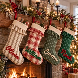 May include: Four Christmas stockings hanging in a row, each featuring a cream-coloured cuff with a ruffled edge. The first is beige with brown stripes, the second is red and white plaid, the third is dark green with white stripes, and the fourth is dark green with white stripes. Each stocking is personalised with a name in cursive script: Olivia, William, Emma, and Noah.