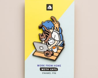 May include: Enamel pin featuring a blue-haired person working on a laptop with three cats. The text on the pin reads "Work from home with cats enamel pin".