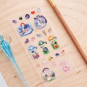May include: A sheet of clear stickers featuring various aquatic-themed designs. The stickers include images of fish, backpacks, handbags, and other aquatic creatures. The stickers are in various colors, including blue, orange, and green.