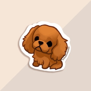 May include: A sticker featuring a cartoon illustration of a brown and white Cavalier King Charles Spaniel dog with big eyes. The dog is looking down and has a sad expression. The sticker is white with a black outline and the text "THOUSANDSKIES" in the bottom right corner.