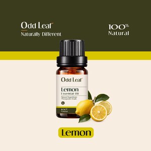 May include: A brown glass bottle of Odd Leaf Lemon Essential Oil with a black cap. The label features the text Odd Leaf, Lemon Essential Oil, Natural Ingredients, Therapeutic Grade, and 100% Natural. A whole lemon and a lemon slice are beside it.