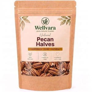 Può includere: Una busta in carta marrone contenente metà di noci pecan. L'etichetta riporta il testo Wellvara, Natural Pecan Halves, Handmade, Pure, Natural, 100% Organic, Chemical Free e Handmade With Care, con una finestra trasparente che mostra le noci.