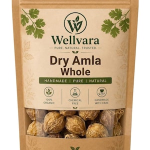 Könnte beinhalten: Ein brauner Kraftpapierbeutel mit ganzen getrockneten Amla-Früchten. Das Etikett zeigt das Wellvara-Logo, den Text Dry Amla Whole sowie Symbole für 100% Bio, chemiefrei und handgefertigt. Der untere Teil ist durchsichtig und zeigt die Früchte.