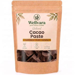May include: A brown paper pouch containing dark brown cacao paste chunks. The label features the Wellvara logo, the text Natural Cacao Paste, and icons indicating 100% organic, chemical free, and handmade with care, with leaf illustrations.