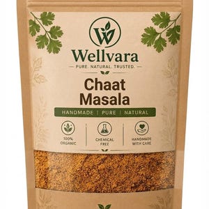 May include: A brown paper pouch containing Chaat Masala spice blend. The label features the Wellvara logo, text reading 100% Organic, Chemical Free, and Handmade With Care, along with a clear window showing the brown, granular spice mixture inside.