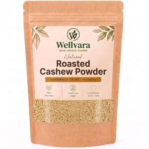 May include: A light brown stand-up pouch containing roasted cashew powder. The label features the Wellvara logo, the text Natural Roasted Cashew Powder, and icons for 100% organic, chemical free, and handmade with care. A clear window shows the powder.