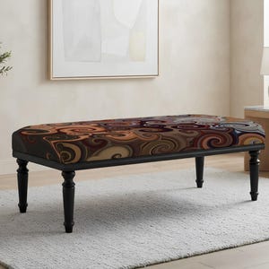May include: A rectangular upholstered bench featuring a dark frame with four turned legs. The seat cushion displays a multi-colored pattern of swirling, abstract shapes in shades of brown, tan, orange, black, and muted blue, creating a continuous design.