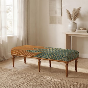 May include: A rectangular upholstered bench with four turned wooden legs. The seat features a patterned fabric with a repeating design of orange, yellow, and teal blue scale-like shapes and linear stripes across the top surface.