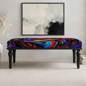 May include: A rectangular bench featuring a vibrant, multi-colored marbled pattern on the seat cushion with swirling hues of blue, red, purple, and green. The bench is supported by four black, turned wooden legs with a classic, rounded design.