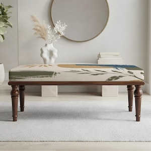 May include: A rectangular bench with four dark brown turned wooden legs and a cushioned seat featuring an abstract print. The upholstery displays a cream background with painted brushstroke designs in olive green, tan, and deep blue, including botanical leaf motifs.