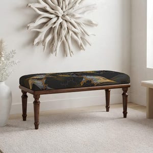 May include: A rectangular bench featuring a dark charcoal gray upholstered seat with a repeating abstract pattern in shades of gold, blue, and white. The bench is supported by four turned wooden legs finished in a rich, dark brown wood tone.