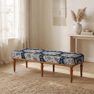 May include: A rectangular bench with a cushioned seat featuring a dark blue, white, and muted red floral pattern. The bench is supported by six turned wooden legs in a medium brown finish, providing a stable base for the upholstered top.