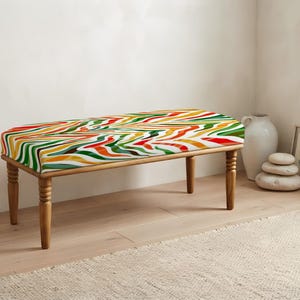 May include: A rectangular bench featuring four turned wooden legs and a cushioned seat upholstered in a vibrant fabric with a multi-colored wavy zebra-like pattern in shades of red, orange, yellow, dark green, and white across the surface.