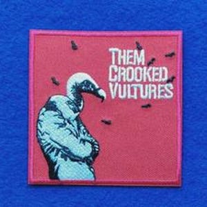May include: A square embroidered patch with a red background featuring a light blue vulture with black details. The text THEM CROOKED VULTURES is embroidered in white in the upper right corner, surrounded by small black embroidered insects.