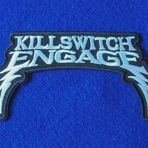 May include: An embroidered patch featuring the text KILLSWITCH ENGAGE in light blue thread on a black background. The lettering is arched with stylised lightning bolt accents extending downwards from both ends of the design.