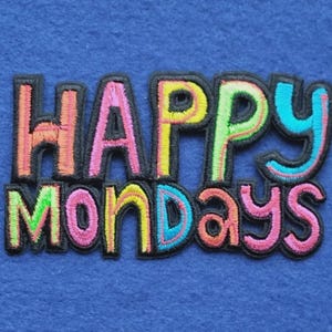 Può includere: Una toppa ricamata che presenta il testo HAPPY MONDAYS in un design multicolore. Le lettere sono delineate con filo nero e riempite con tonalità vivaci di arancione, rosa, giallo, verde e blu, creando un aspetto audace e colorato.