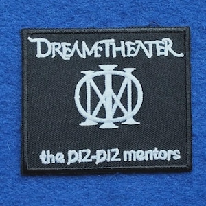 Può includere: Una toppa rettangolare ricamata nera con il testo bianco DREAM THEATER in alto, un logo circolare bianco centrale con linee che si intersecano e il testo bianco the DIZ-DIZ mentors in basso con un bordo nero cucito.