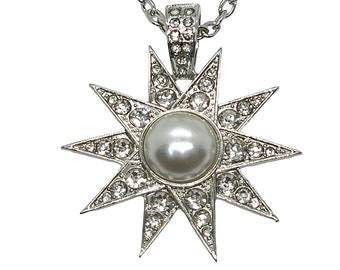 May include: A silver necklace with a large, eight-pointed star pendant. The star is encrusted with clear rhinestones and has a large, white pearl in the center.