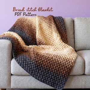 May include: A crochet blanket featuring a textured braid stitch pattern in an ombre color gradient transitioning from dark charcoal gray to medium brown and light cream. The text "Braid stitch blanket PDF Pattern" is printed above the blanket.
