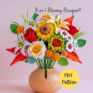 Puede incluir: Un ramo de flores de ganchillo con girasoles, rosas rojas, lirios blancos y pequeñas margaritas blancas con hojas verdes y follaje naranja en un jarrón de madera redondo. El texto 8-in-1 Bloomy Bouquet! y PDF Pattern aparece en la imagen.