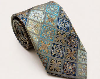 May include: A necktie featuring a repeating diamond grid pattern. Each diamond contains an intricate, symmetrical floral-inspired motif in shades of metallic gold, deep blue, and light teal, set against a muted grey background fabric.