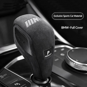 May include: A dark gray suede gear shift knob cover for a BMW vehicle. The cover features the M logo, the word UNLOCK, and the letter P. Text on the image reads Exclusive Sports Car Material and BMW-Full Cover. The cover has a textured finish.