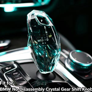 May include: A clear, faceted crystal gear shift knob for a BMW vehicle, featuring an internal black display with white gear indicators including P, R, N, D, and M/S. The text 'Fit for BMW No-Disassembly Crystal Gear Shift Knob' is printed at the bottom.