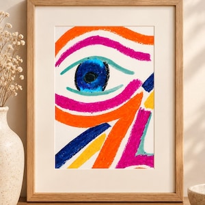 Puede incluir: Una lámina artística enmarcada que presenta una ilustración abstracta de un ojo creada con trazos de cera en naranja, rosa intenso, azul brillante y amarillo. La obra está en un marco de madera clara con un borde de paspartú blanco.