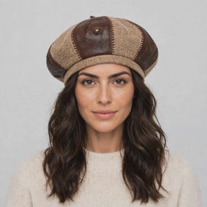 May include: A multi-panel beret featuring alternating sections of brown leather and tan herringbone patterned fabric. The cap is constructed with visible stitching along the seams where the leather and fabric panels meet, and includes a small leather tab detail.
