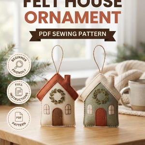 May include: Two felt house ornaments with hanging loops. One has a rust roof and cream walls, the other a cream roof and sage walls. Both feature a small embroidered wreath, a door, and two windows. Text reads: ThreadAndNook FELT HOUSE ORNAMENT PDF SEWING PATTERN BEGINNER FRIENDLY FULL INSTRUCTIONS PDF PATTERN INSTANT DIGITAL DOWNLOAD.
