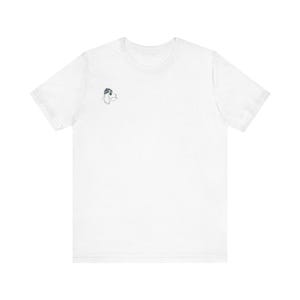 Può includere: Una t-shirt bianca a maniche corte con una piccola illustrazione a linee bianche e nere di un cane che indossa un berretto sulla parte superiore sinistra del petto. La maglietta ha un girocollo e una vestibilità standard, dall'aspetto pulito.