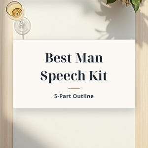 May include: A rectangular white card featuring the dark blue text Best Man Speech Kit and 5-Part Outline, with a thin gold horizontal line separating the two lines of text, presented on a light-colored surface with a glass and flowers.