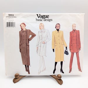 May include: A Vogue basic design sewing pattern envelope, number 1853, featuring illustrations of four different coat and jacket styles in brown, white, yellow, and red. The white paper envelope includes a barcode and size information 14-16-18.