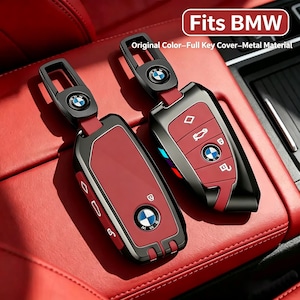 May include: Two metal key covers for BMW key fobs, featuring a red and black color scheme with the BMW logo. The text "Fits BMW" and "Original Color-Full Key Cover-Metal Material" is visible. These covers include a matching metal keychain attachment.