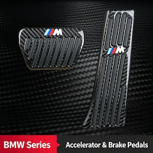 Puede incluir: Un juego de pedales para coche con acabado de fibra de carbono y tiras de agarre de goma negra. Los pedales de acelerador y freno muestran el logotipo M con rayas azules, moradas y rojas. Se lee el texto BMW Series Accelerator & Brake Pedals.
