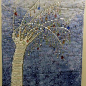 May include: A white fabric tree with a blue and purple background. The tree is decorated with beads and sequins, creating a shimmering effect. The tree is a unique and decorative piece of art.