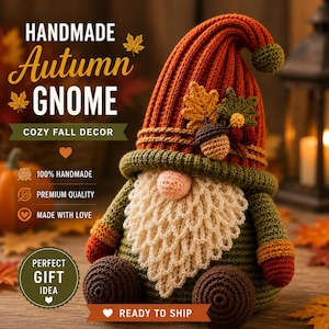 May include: A handmade crochet gnome featuring a tall, ribbed burnt orange hat topped with a small pom-pom. The gnome has a textured cream-colored beard, a round nose, and dark brown feet. The hat is decorated with crocheted autumn leaves and an acorn.