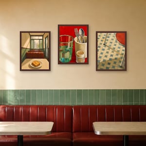 May include: Three framed rectangular wall art prints displayed in a row. The left print shows a diner interior with a plate of food. The center print features a glass, cutlery, and a toothpick holder on a red background. The right print depicts a tiled floor.