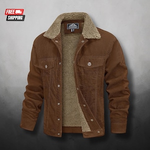 May include: A brown corduroy jacket featuring a tan sherpa fleece lining and collar. The jacket includes a button-up front closure, two chest pockets with buttoned flaps, and a small rectangular brand label on the inner neck area.