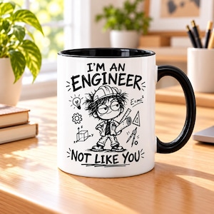 Puede incluir: Una taza de cerámica blanca con asa e interior negros, que presenta una ilustración gráfica en negro de un ingeniero de dibujos animados con casco, rodeado de símbolos de ingeniería y el texto I'M AN ENGINEER NOT LIKE YOU en tinta negra.