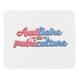 Könnte beinhalten: Ein rechteckiges weißes Mauspad mit dem Text Auxiliaire de puériculture in einer 3D-Blasenschrift. Die Buchstaben sind abwechselnd rosa und blau gefärbt und haben eine braune Umrandung. Kleine rosa und blaue Herzen flankieren das Wort de.