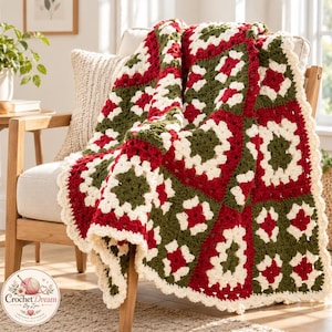 May include: A handmade crochet blanket featuring a repeating granny square pattern in alternating colors of deep red, forest green, and cream. The blanket has a scalloped cream-colored border and is draped over a wooden chair.
