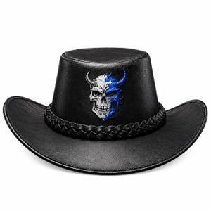 May include: A black cowboy hat with a textured finish and a braided hatband. The front of the crown features a graphic print of a split-colored skull, with one side in white and the other side in blue, both sides featuring horn details.