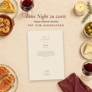 May include: A printable PDF menu titled Date Night zu zweit Tapas-Abend Sevilla, surrounded by plates of shrimp, tortilla, olives, cheese, bread, two glasses of red wine, a lit candle, and a dark red napkin, all arranged on a light surface.