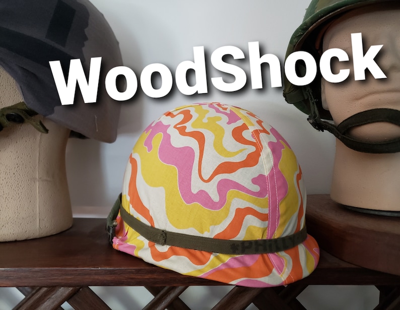 May include: A colourful helmet with a pink, orange and yellow swirl pattern. The helmet has a green strap with the word "PHILLY" printed on it. The helmet is sitting on a wooden surface.