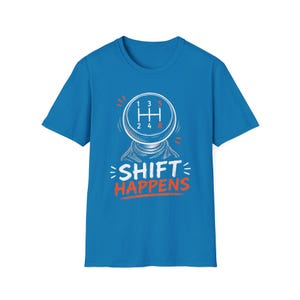 May include: A bright blue short-sleeve t-shirt featuring a graphic of a manual transmission gear shift knob. The design includes the gear pattern with numbers 1 through 5 and R, along with the white and orange text that reads SHIFT HAPPENS.